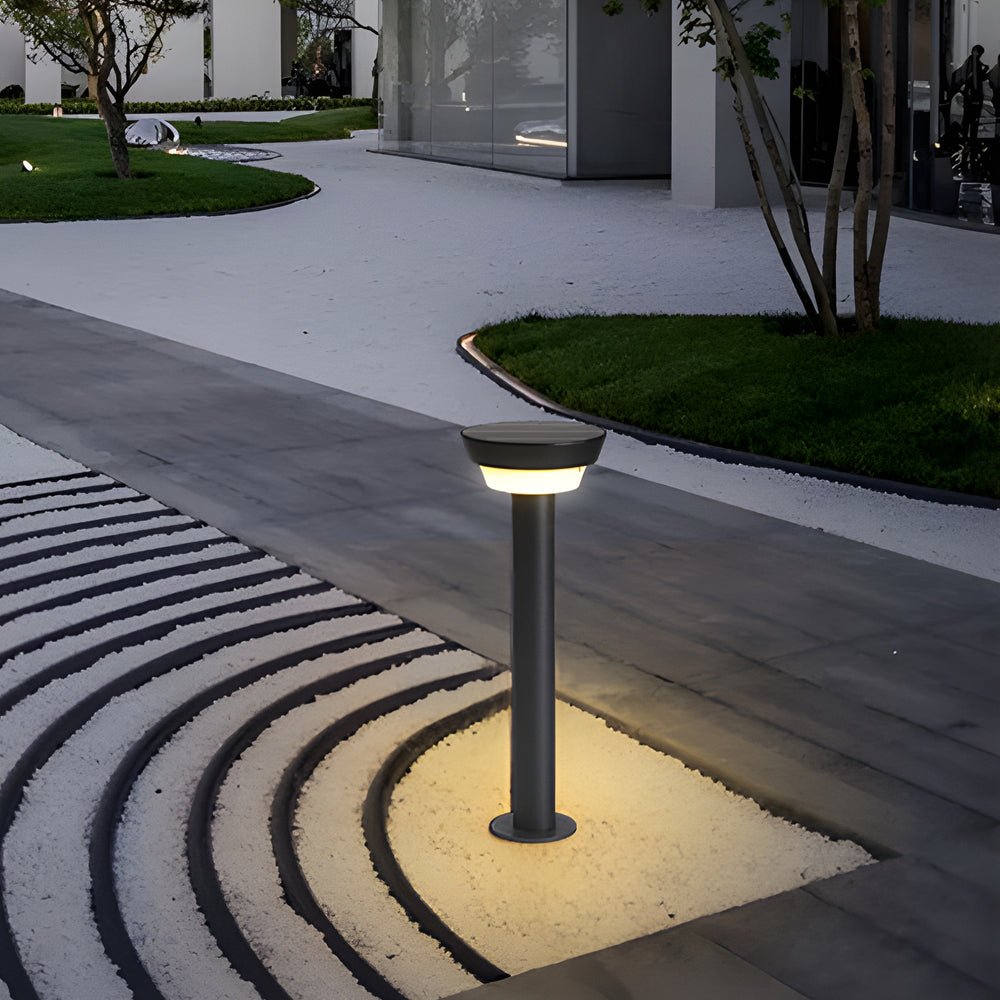 Solar powered garden path lights placed along a curved concrete walkway creating elegant outdoor night lighting.