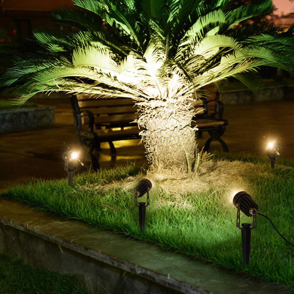 Solar powered landscape spotlight highlighting a tree in a garden