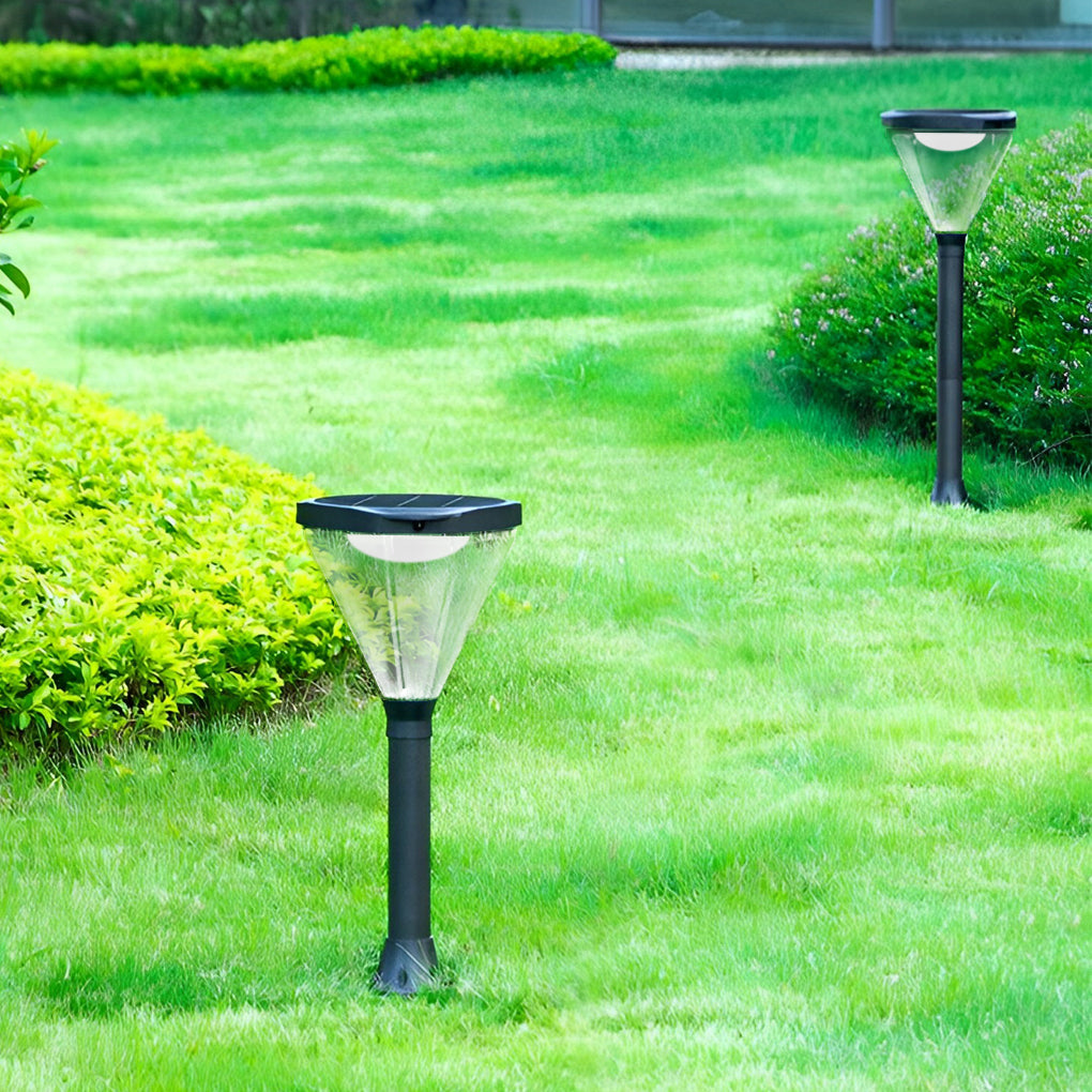 Solar powered lawn light with a modern black finish, illuminating a green lawn.