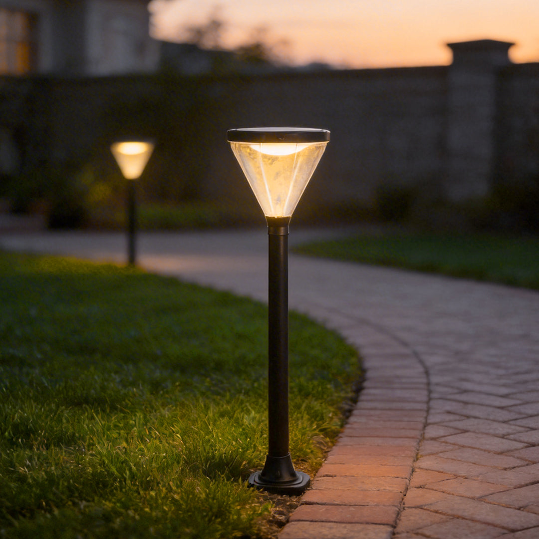 Solar powered lawn light with a modern design, illuminating a curved garden walkway.