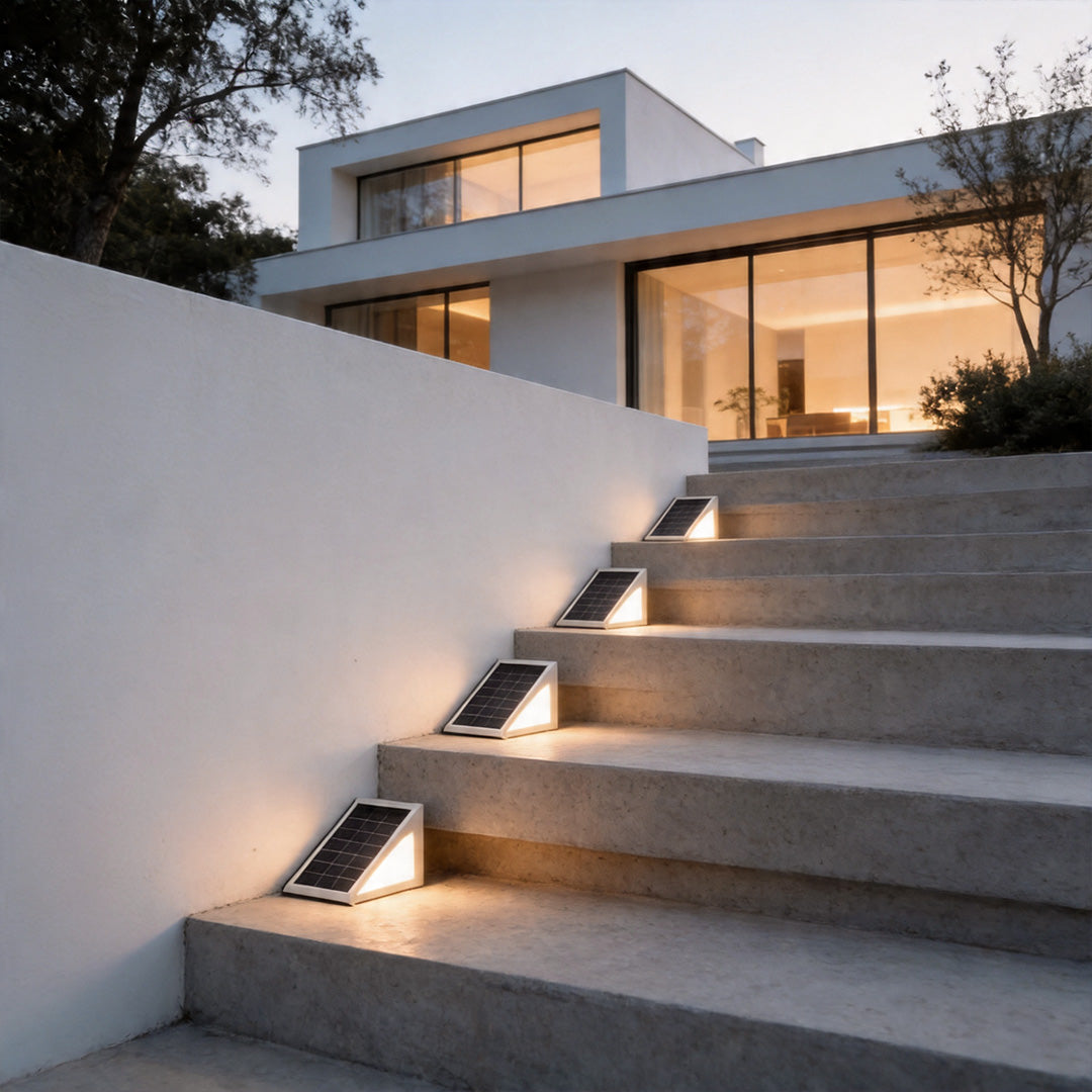Solar powered lights for steps illuminating modern concrete stairs leading up to a white house.