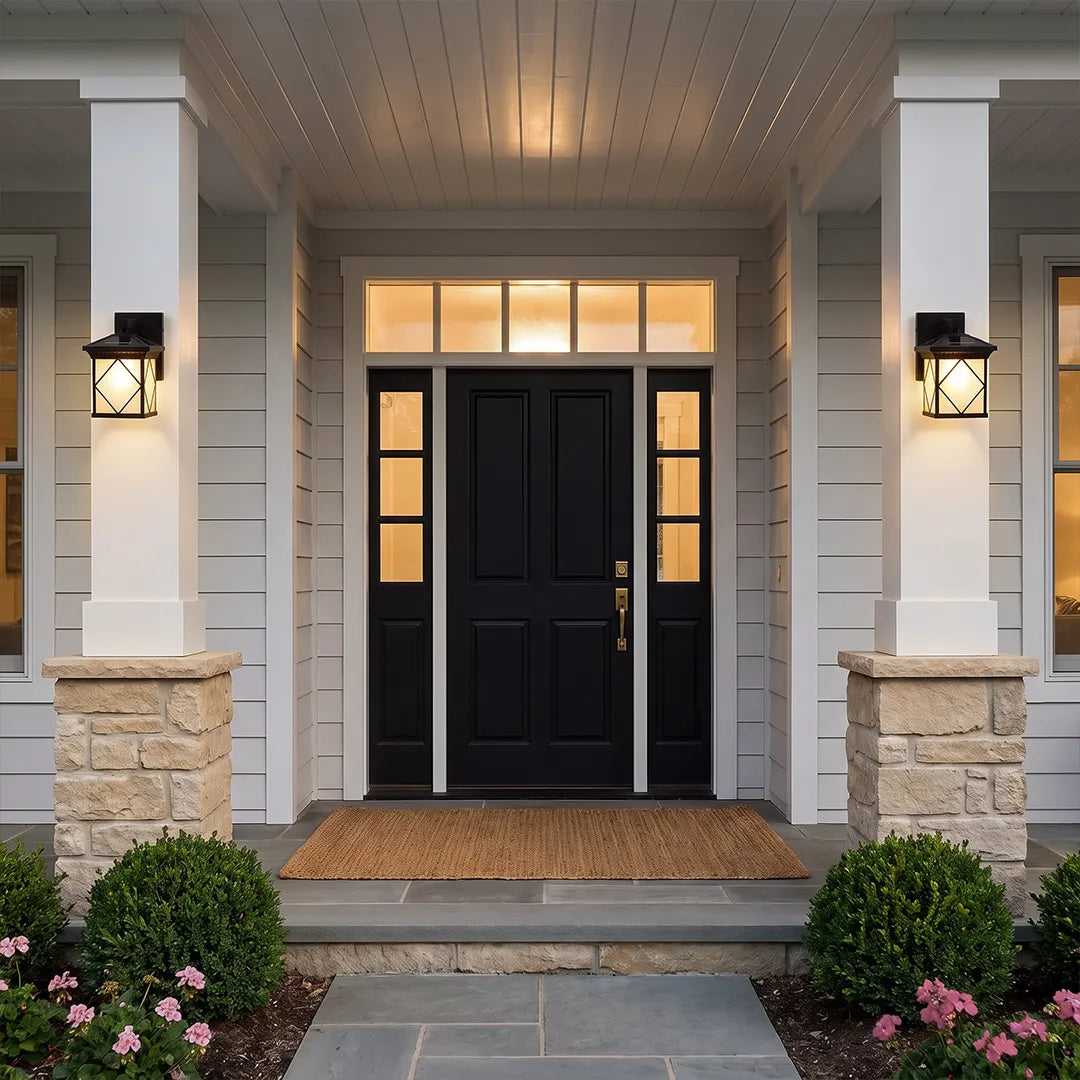 Solar powered outdoor wall sconces flanking a modern black front door on a covered porch.