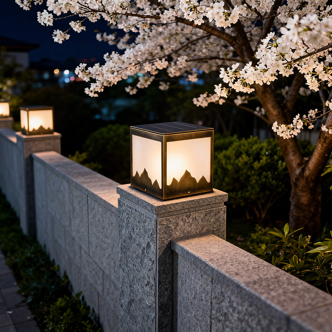 Solar powered pillar lights glowing softly beside a blooming tree, perfect for outdoor evening decor.