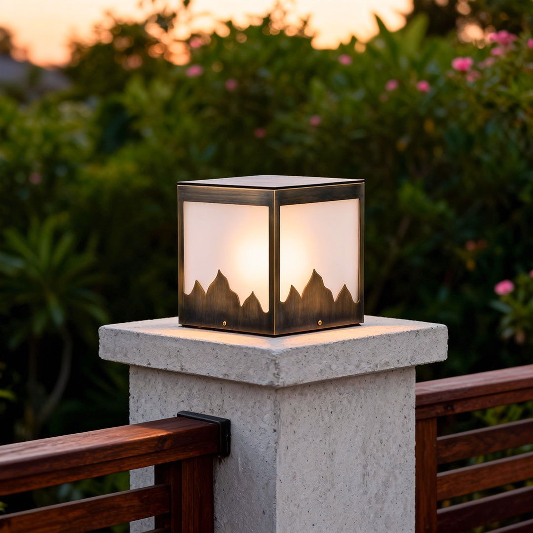 Solar powered pillar lights illuminating a stone pillar in a garden during sunset, creating a cozy atmosphere.