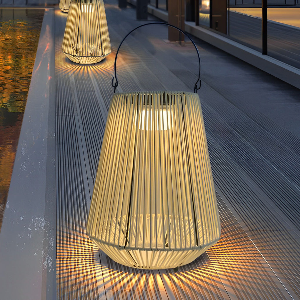 Close-up of a solar rope lantern casting patterned light on an outdoor walkway at night.