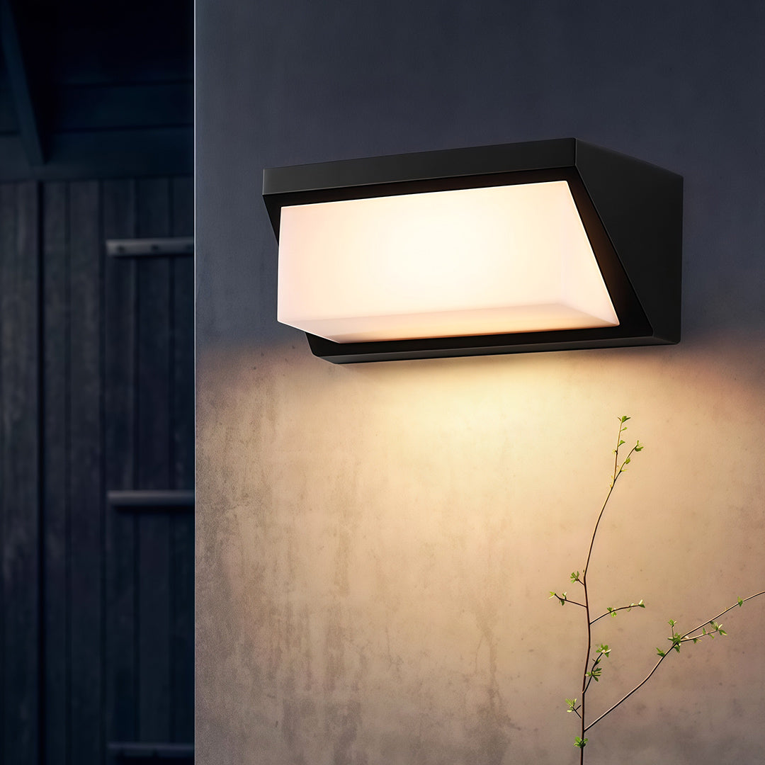 Solar outdoor wall mount light with a modern design, mounted on a garden wall, offering energy-efficient illumination.