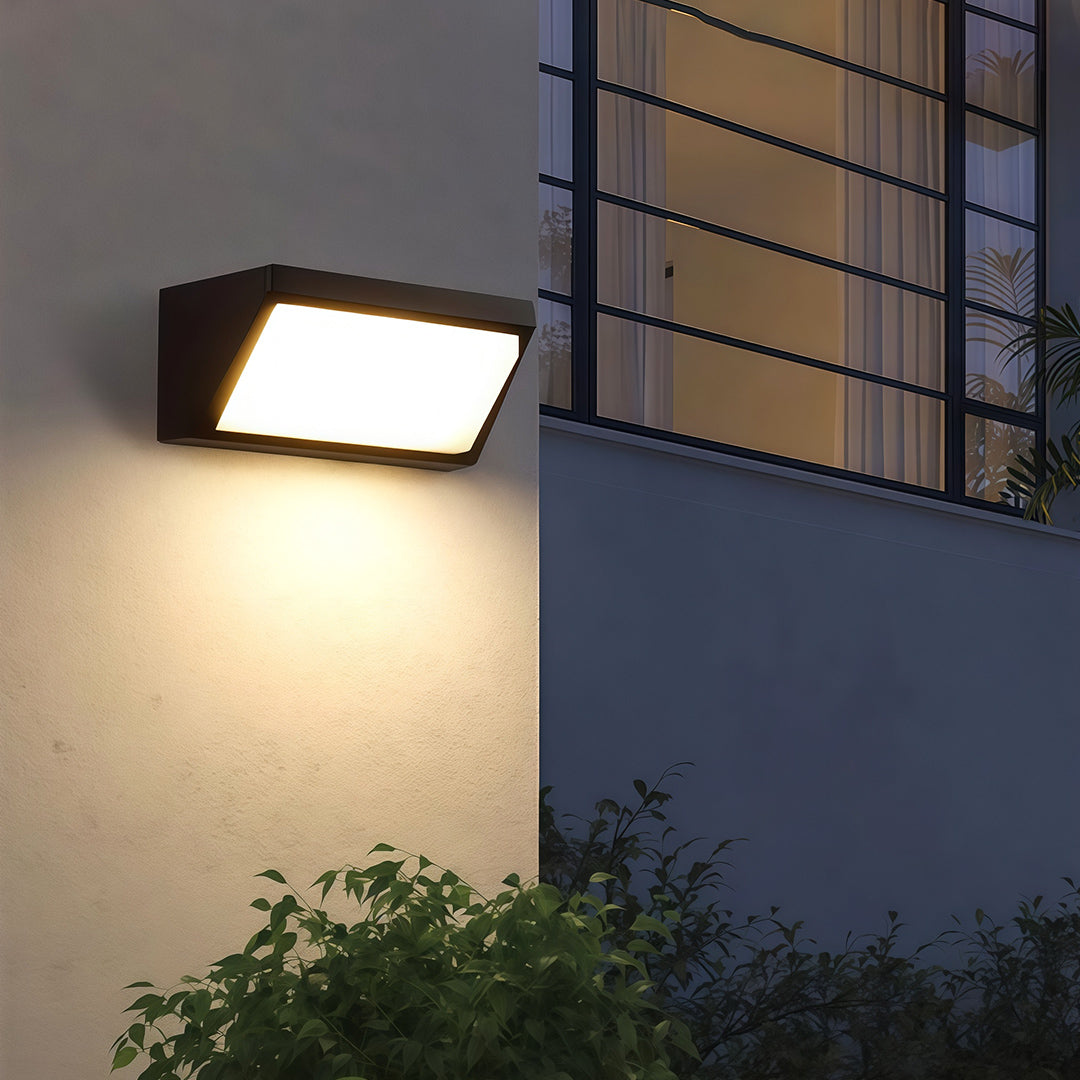Sleek solar outdoor wall mount light mounted on a stone wall, highlighting the exterior design with subtle illumination.