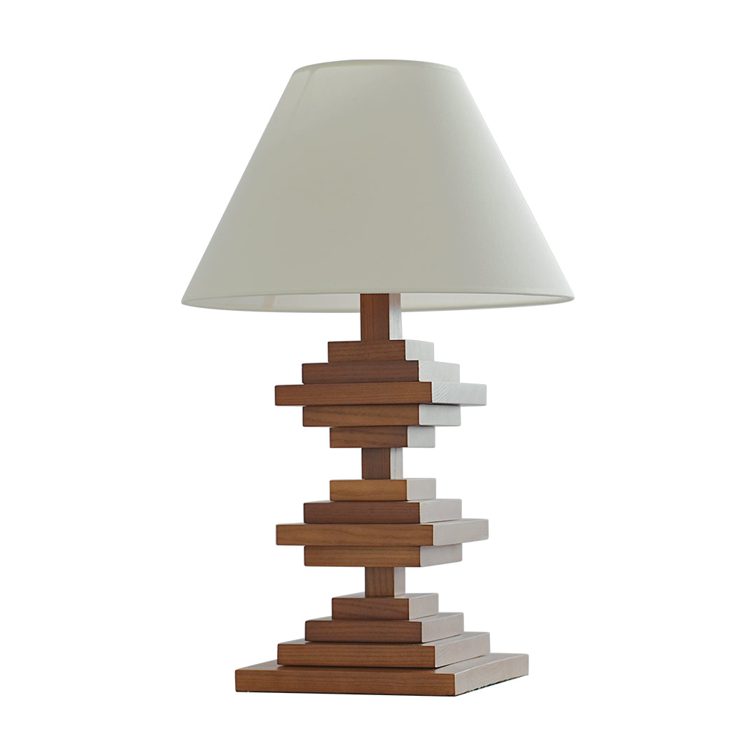 Solid wood table lamp with stacked geometric base and fabric lampshade.