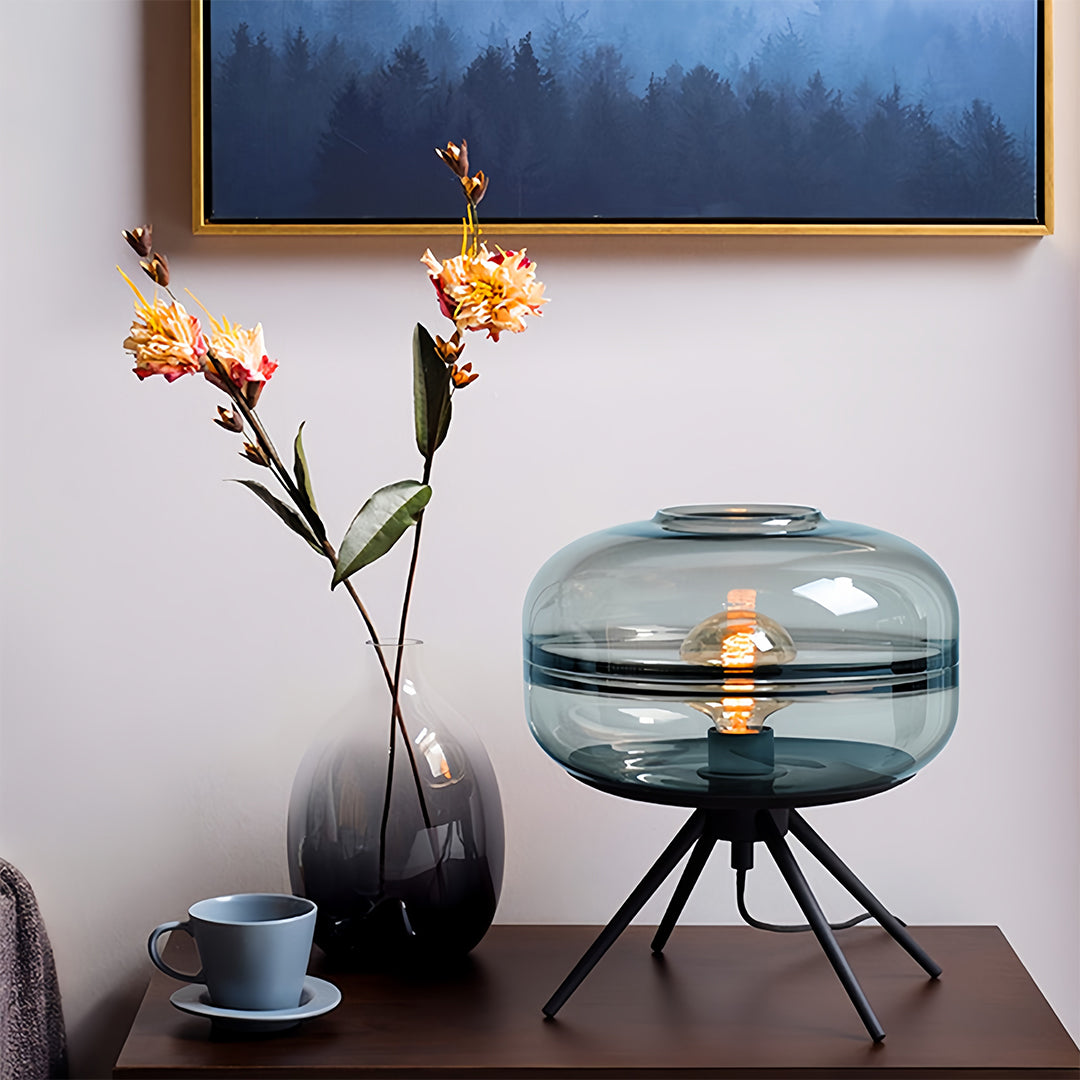 Sophisticated glass small table lamp display showing blue-tinted shade with elegant black tripod base design
