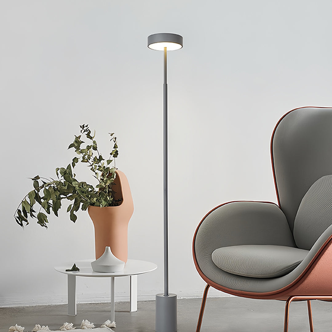 Sophisticated LED petite floor lamp with circular shade providing elegant uplighting in minimalist home interior setting