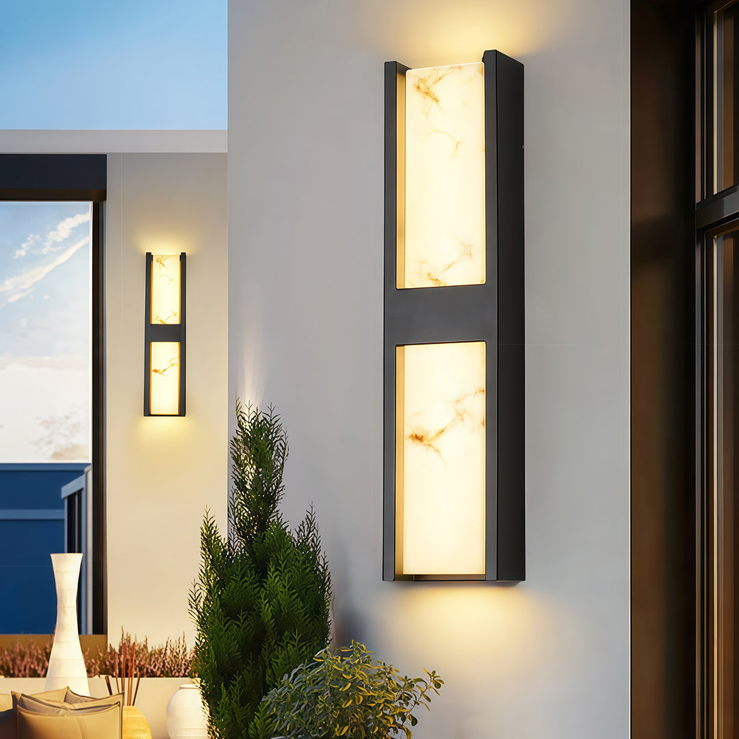 Sophisticated LED wall sconce light fixtures with glass shade chandelier design providing ambient lighting on wood-accented entrance.