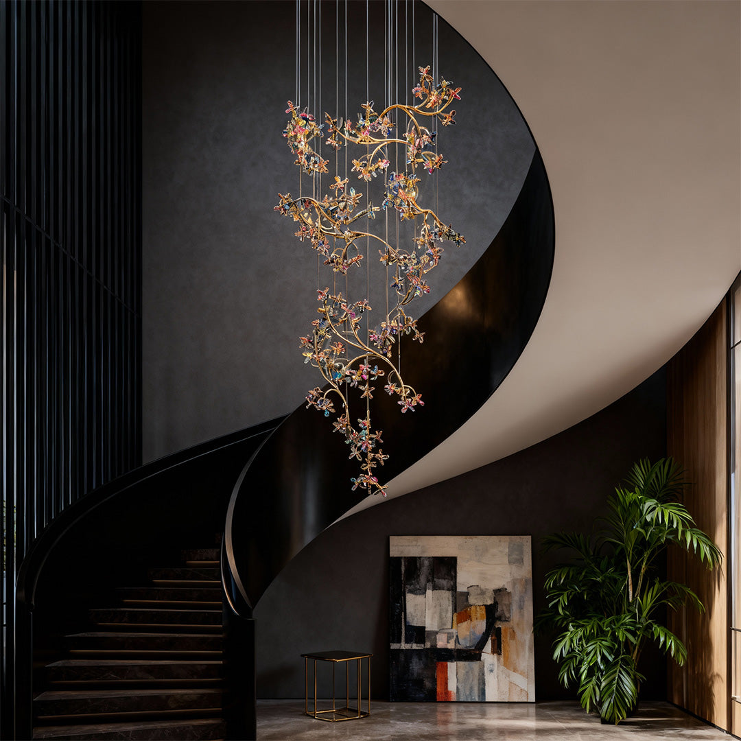 Sophisticated modern staircase chandelier with glass shade chandelier design illuminating dramatic black curved staircase in contemporary entry.
