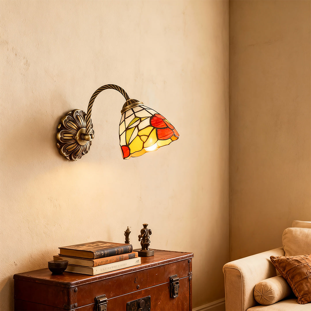 Sophisticated stained glass wall sconce lighting with glass shade chandelier influence providing accent lighting above storage chest.
