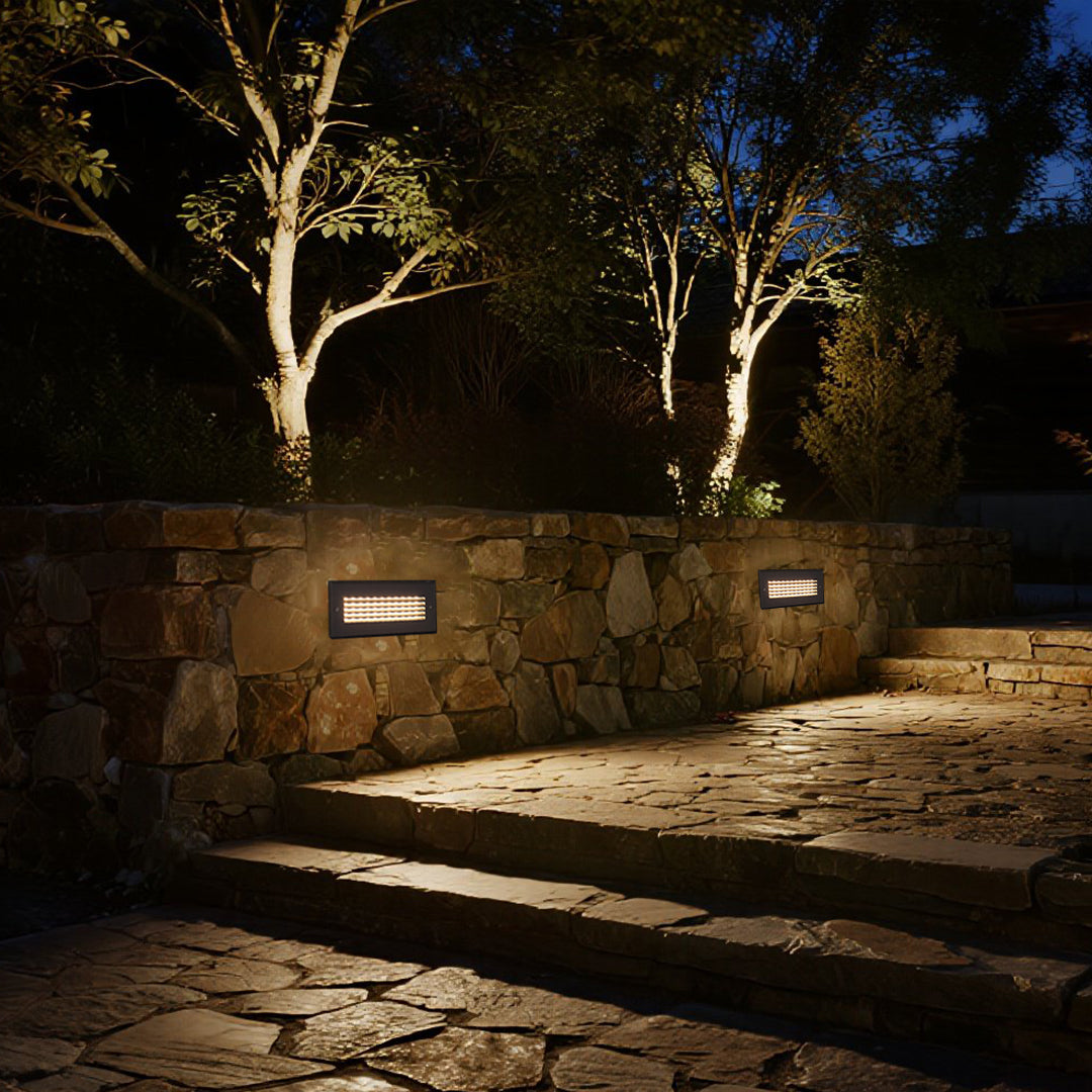 Sophisticated outdoor lighting highlighting natural stone walls and creating dramatic architectural shadows