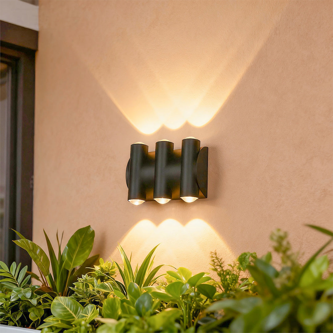 Sophisticated up down lighting wall lights featuring glass shade chandelier influence with warm ambient glow on neutral stucco wall.