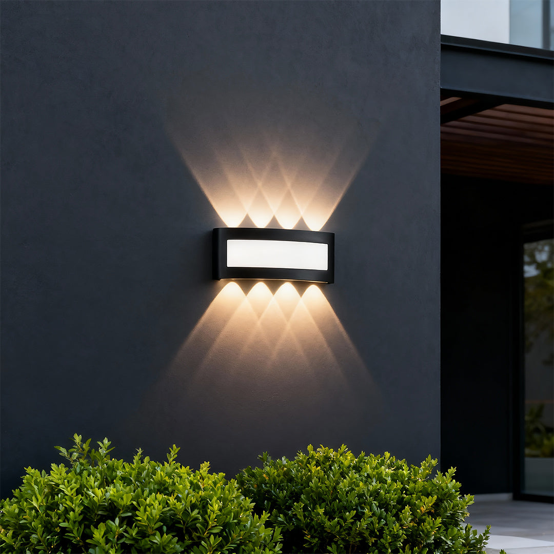 Sophisticated up down wall lights featuring glass shade chandelier influence with distinctive geometric light projection on dark facade.