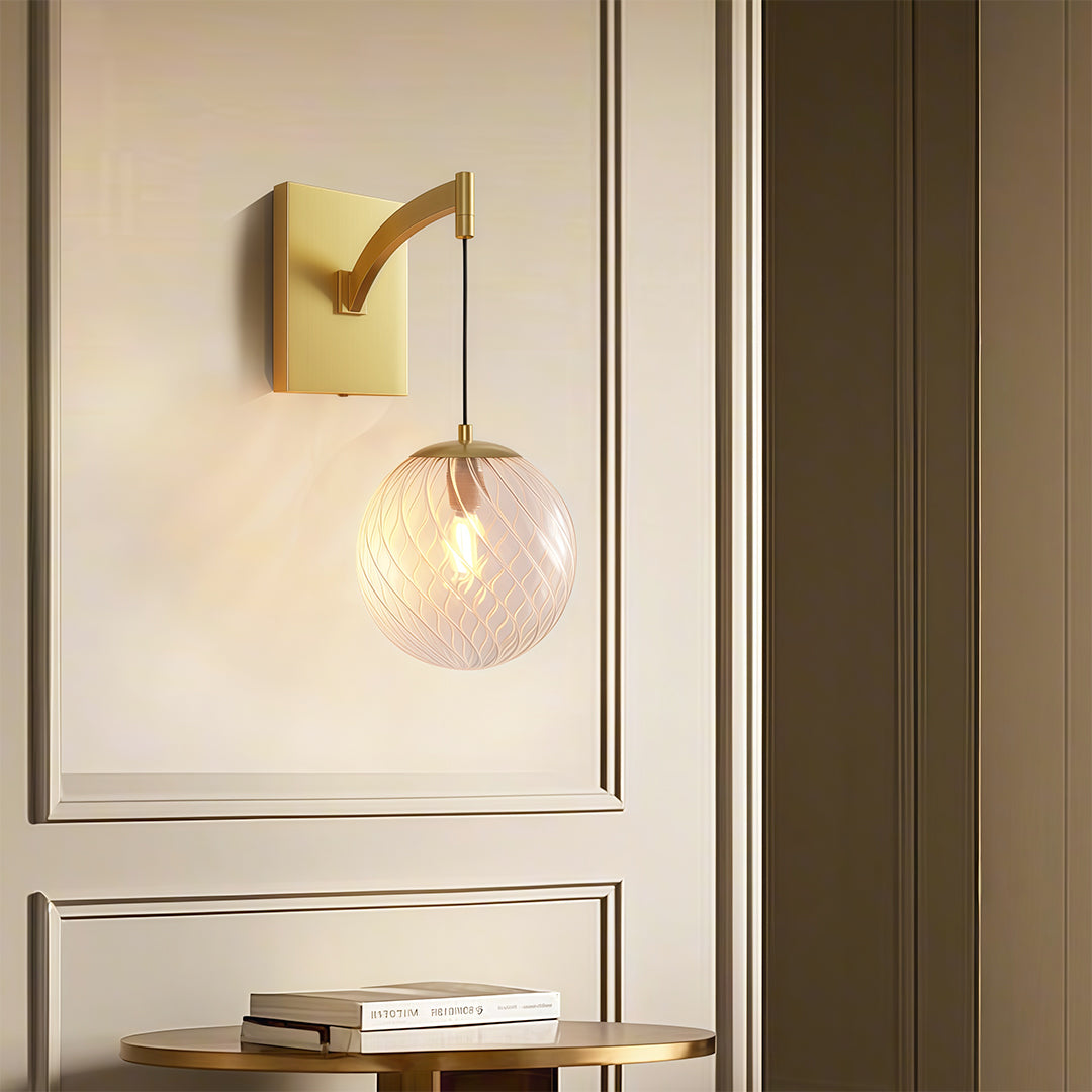 Sophisticated wall mounted pendant light with glass shade chandelier influence illuminating modern entryway with warm ambient glow.