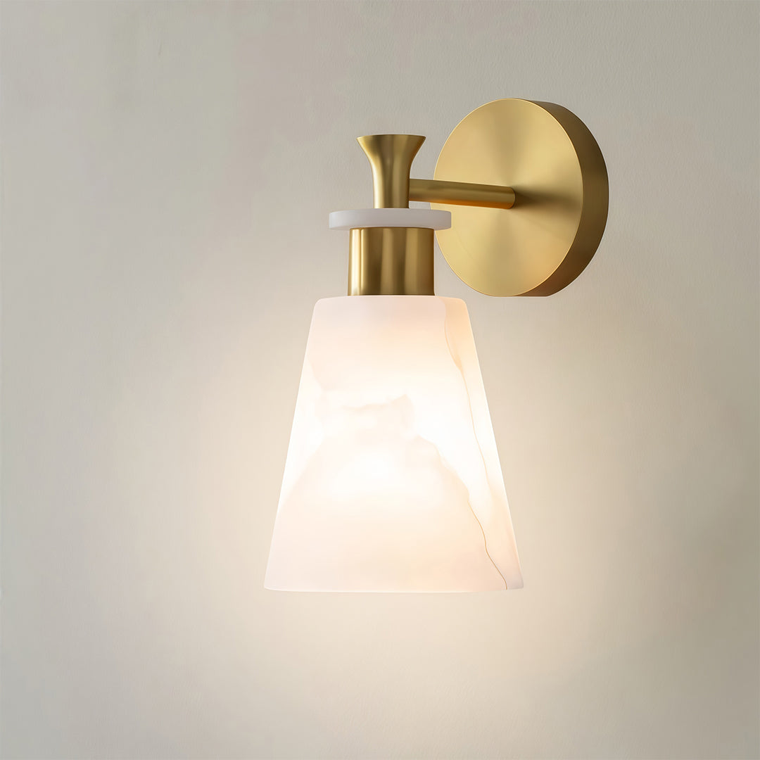 Sophisticated wall sconce LED light with glass shade chandelier influence creating warm accent glow on minimalist white wall.