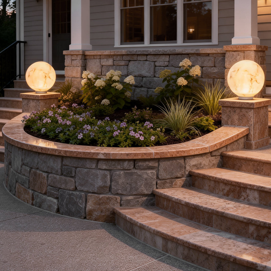 Outdoor pillar lights with a spherical design, enhancing the entrance of a house with soft ambient lighting.