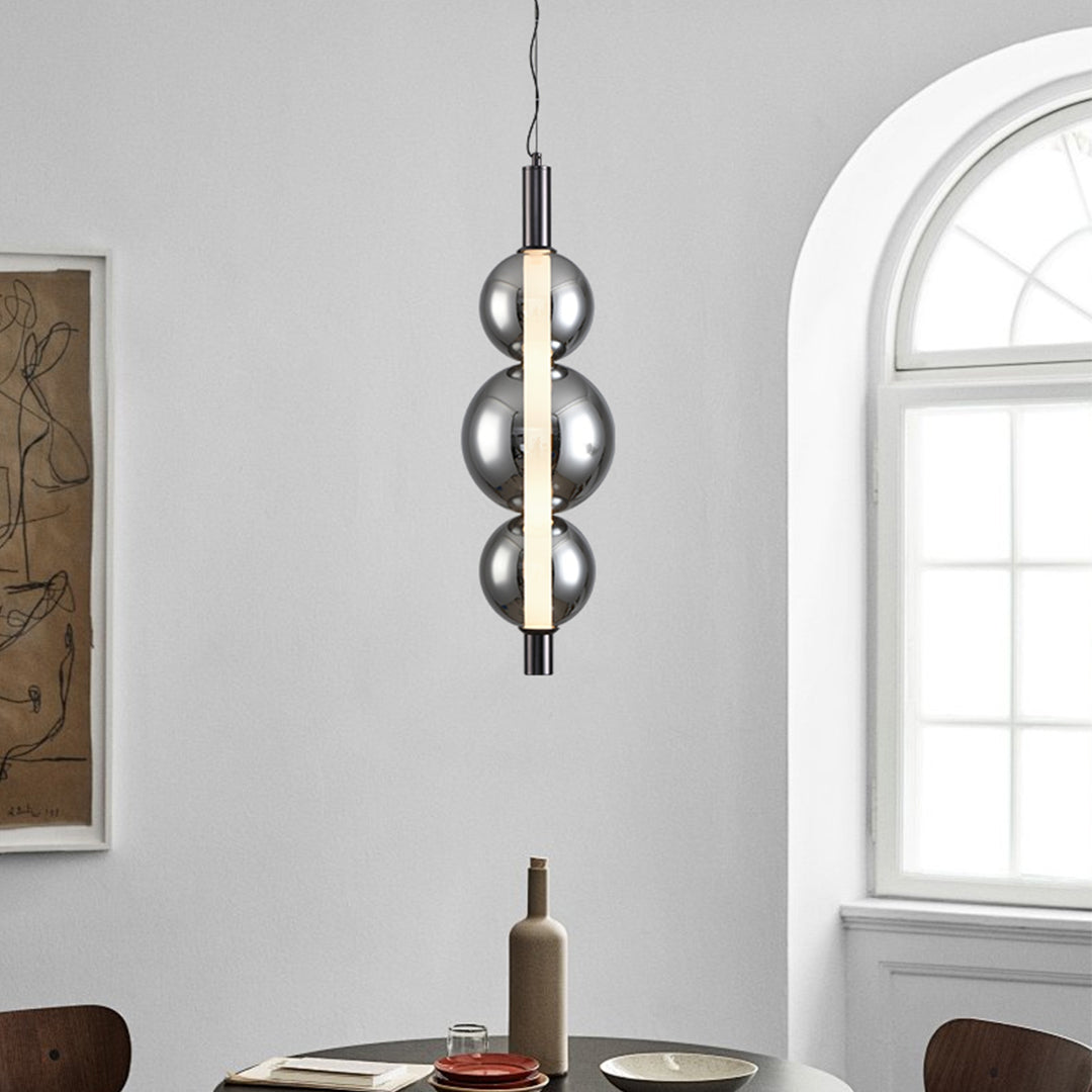 Modern silver pendant light with spherical transparent glass shade and sleek black suspension cord