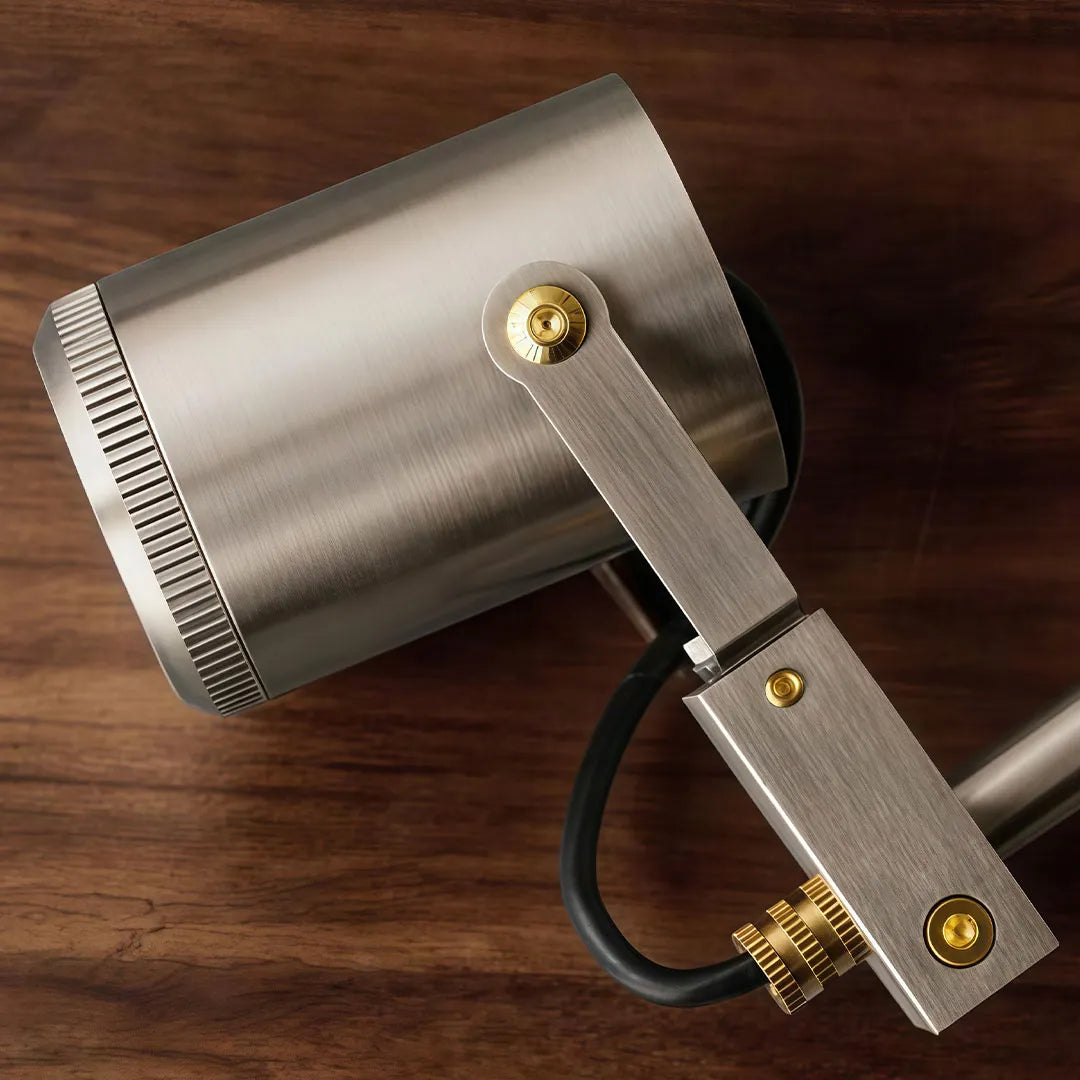 Close-up of spotlight ceiling light showing the brushed metal cylinder and adjustable mounting bracket.