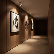 Spotlight ceiling light installed in a dark wood hallway for focused artwork illumination.