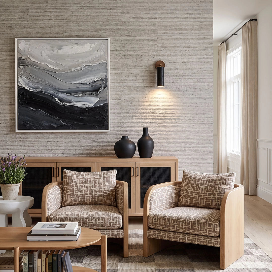 Spotlight wall lights installed above patterned lounge chairs in a bright contemporary living room.