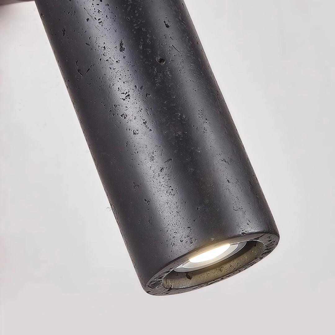 Close-up of spotlight wall lights featuring a textured black cylindrical shade and recessed light source.