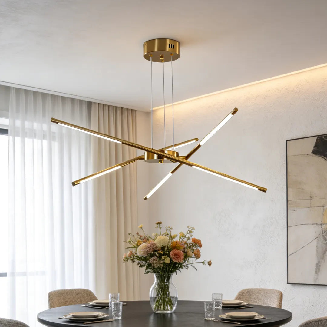 Sputnik chandelier in a brushed gold finish installed above a dining table in a bright contemporary interior with layered ambient lighting.