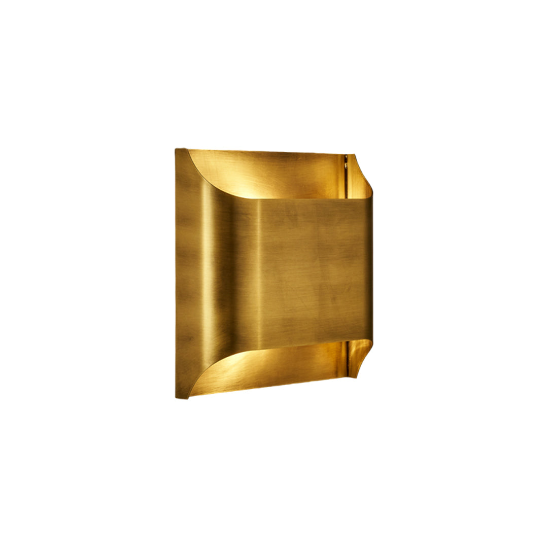 Square brushed brass wall light fixture illuminating with a warm glow isolated on white space.