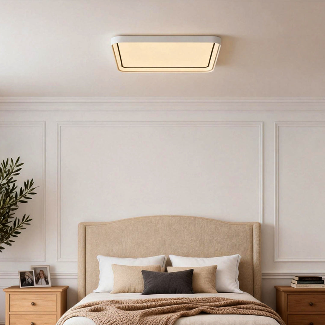 Square flush mount ceiling light installed in a modern bedroom with paneled walls.
