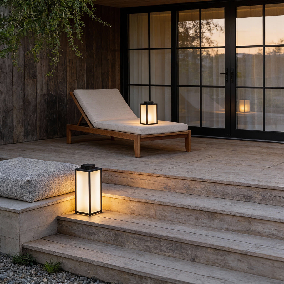 Square handheld lantern illuminating outdoor steps with warm glow at dusk.