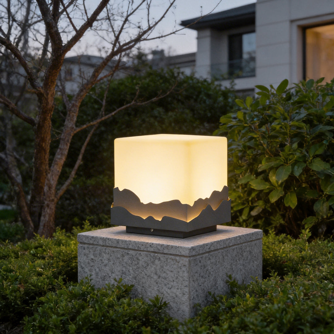 Square landscape light illuminating a modern garden pathway with warm mountain-wave design.