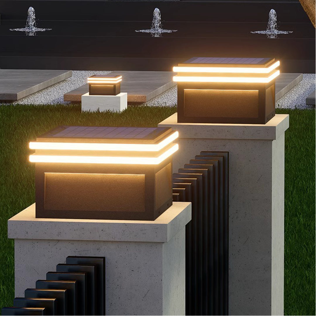 Square metal pillar lights with warm amber LED strips creating inviting outdoor illumination on concrete base