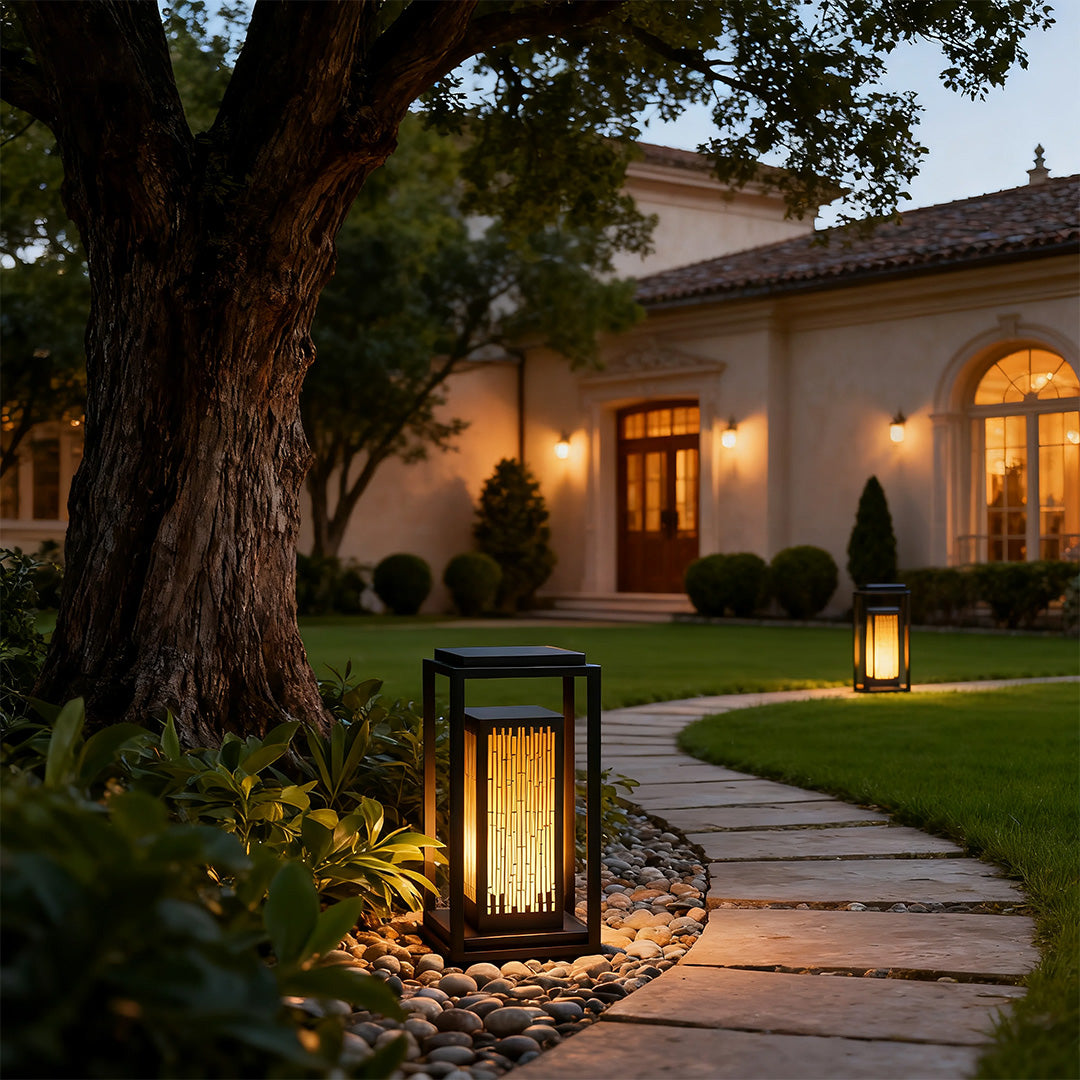 Square outdoor lantern in a garden with plants, adding a contemporary touch to the outdoor space.