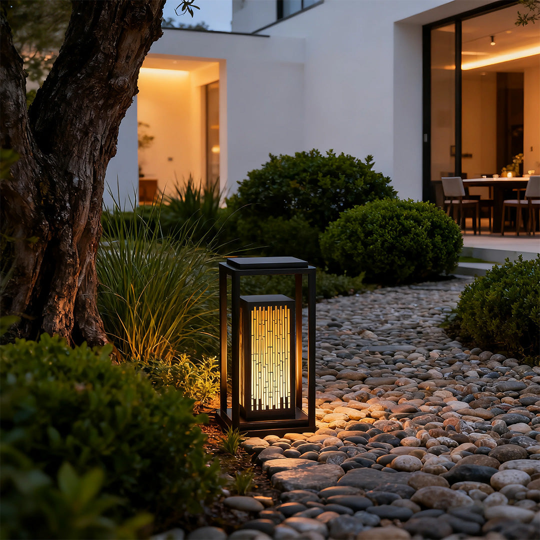 Square outdoor lantern placed near a house entrance, enhancing the outdoor ambiance with subtle lighting.
