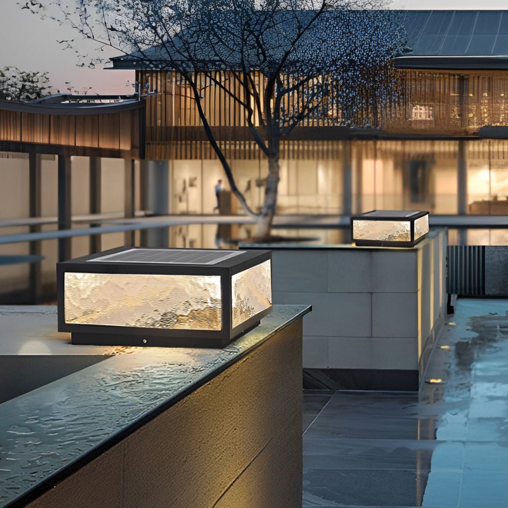 Square outdoor pillar lights installed on a low wall in a contemporary residential courtyard.
