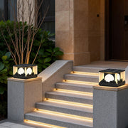 Square outdoor pillar lights illuminating a modern staircase with warm, ambient glow.