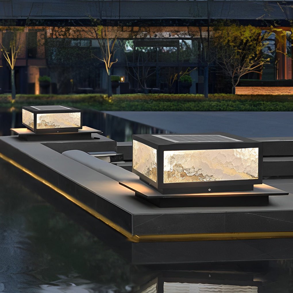 Modern square outdoor pillar lights installed along a water feature in a luxury outdoor space.