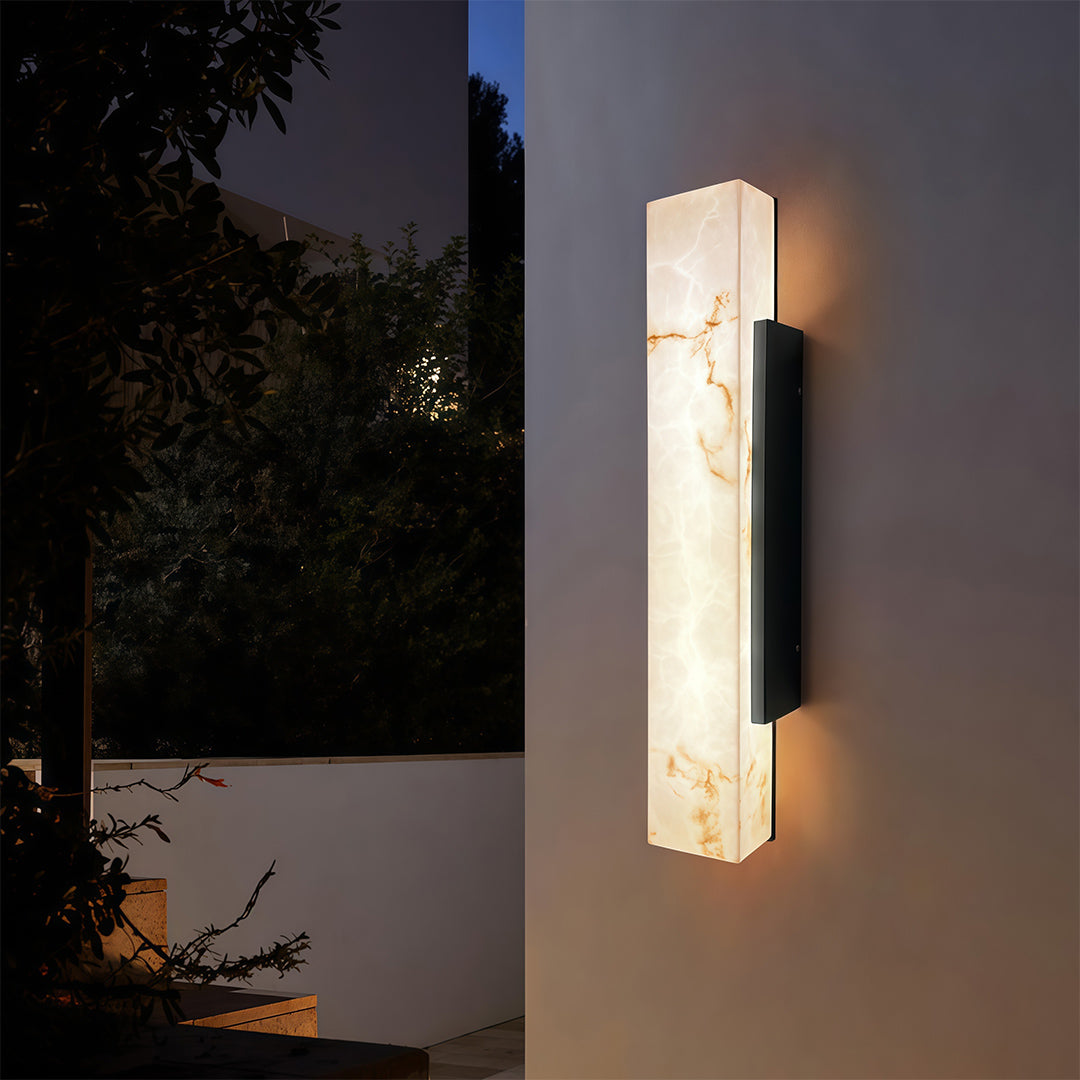 Square outdoor wall lights mounted beside a garden, casting a soft glow for evening ambiance.