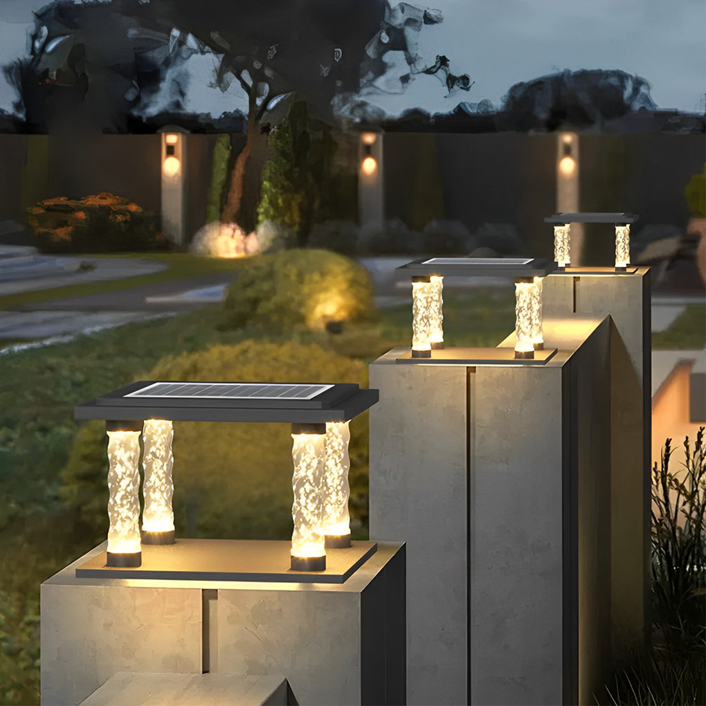 Square pillar lamp with crystal columns, providing elegant light in a garden.