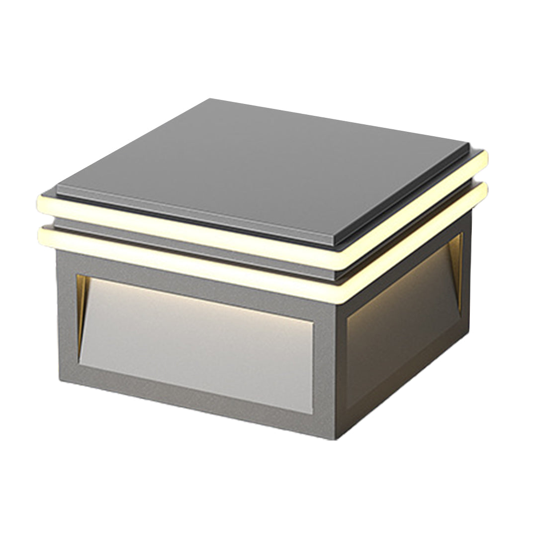 Square outdoor pillar light mounted on stone surface providing ambient illumination in residential landscape setting