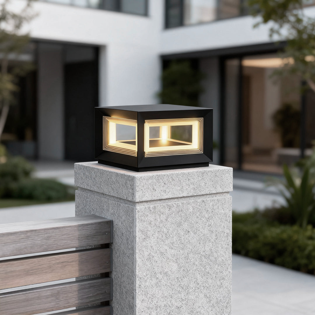Square pillar lights placed on a concrete fence pillar near a house entrance, creating soft ambient lighting for outdoor spaces.