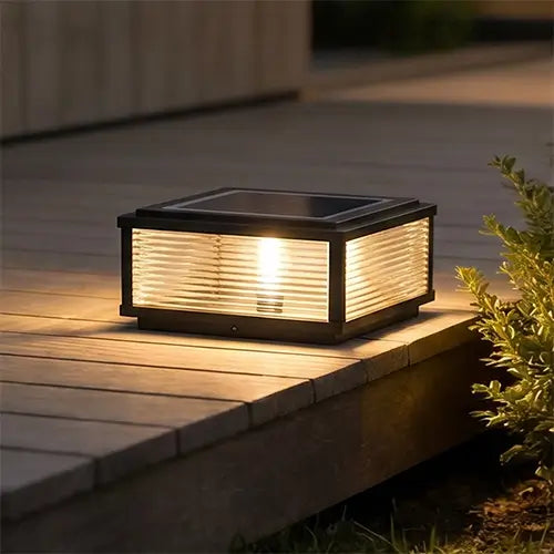 Square solar deck light illuminating a wooden patio at night