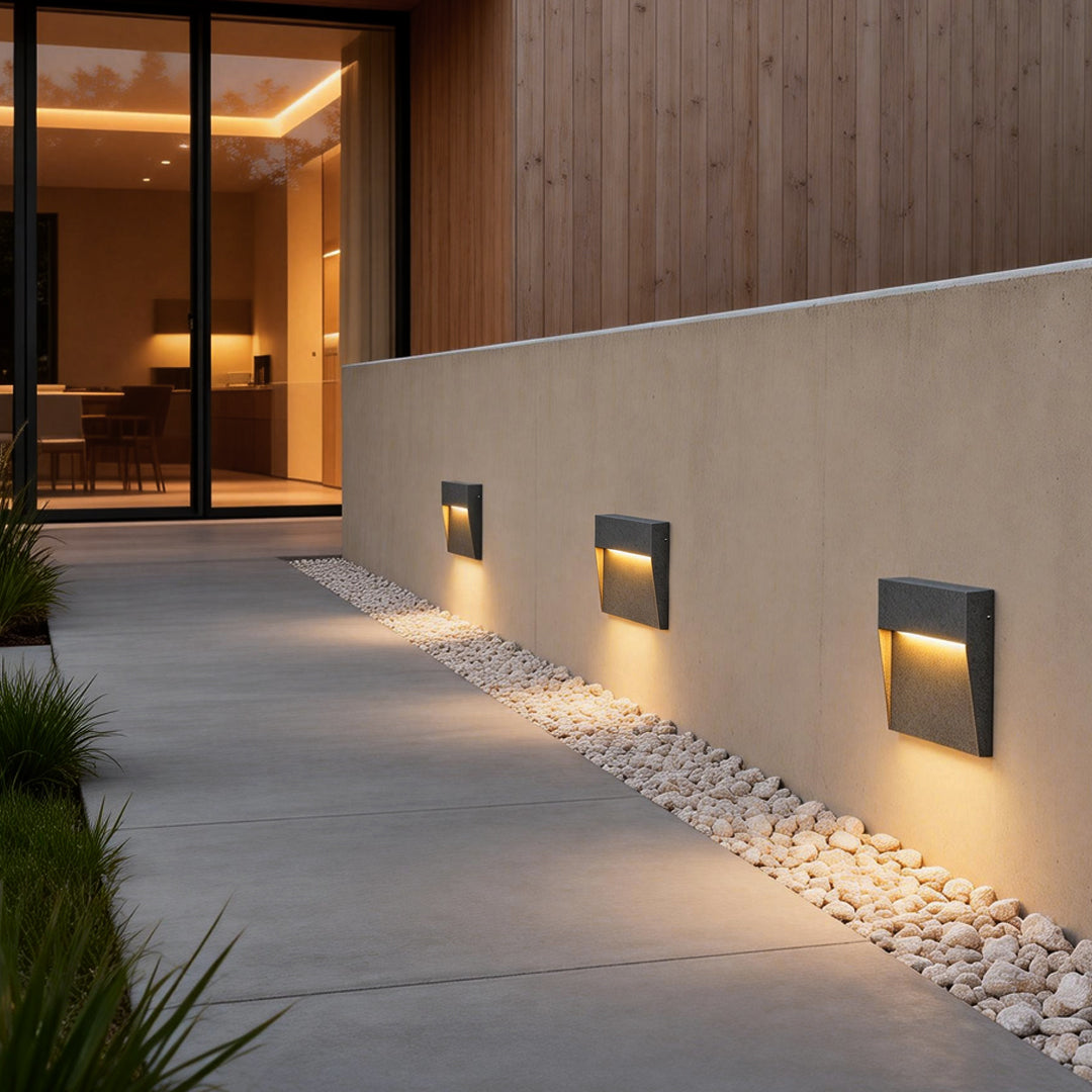 Square stair lights providing soft illumination along a modern outdoor pathway.