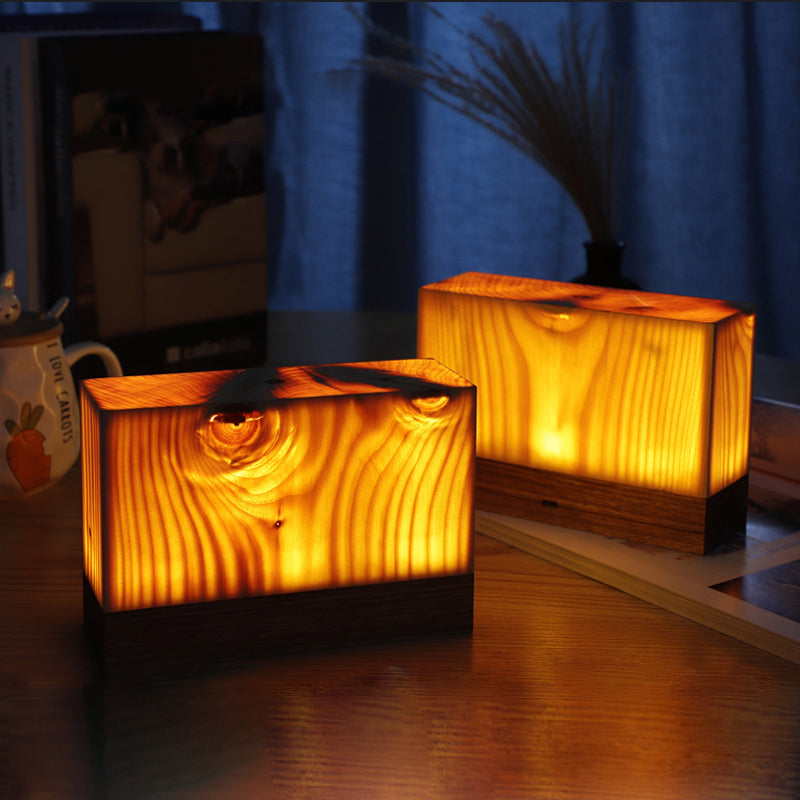 Square wood lamp with a carved star detail, glowing warmly.