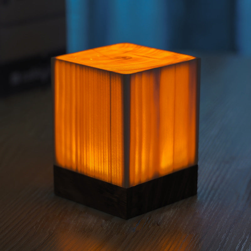 Square wood lamp in cylindrical design, front view of the natural wood.