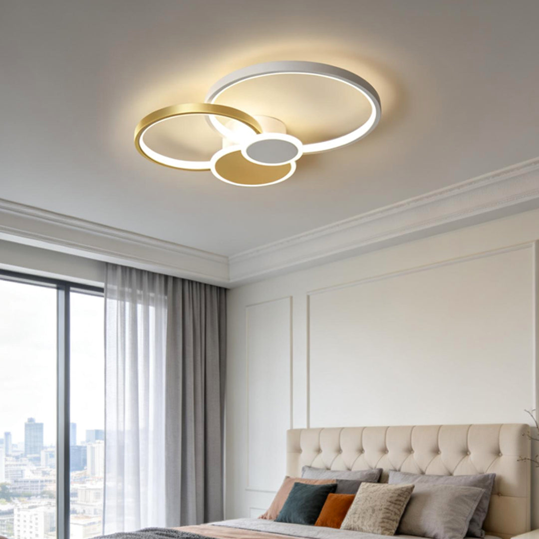 Stacked ring ceiling light mounted above a modern bedroom with soft ambient lighting.