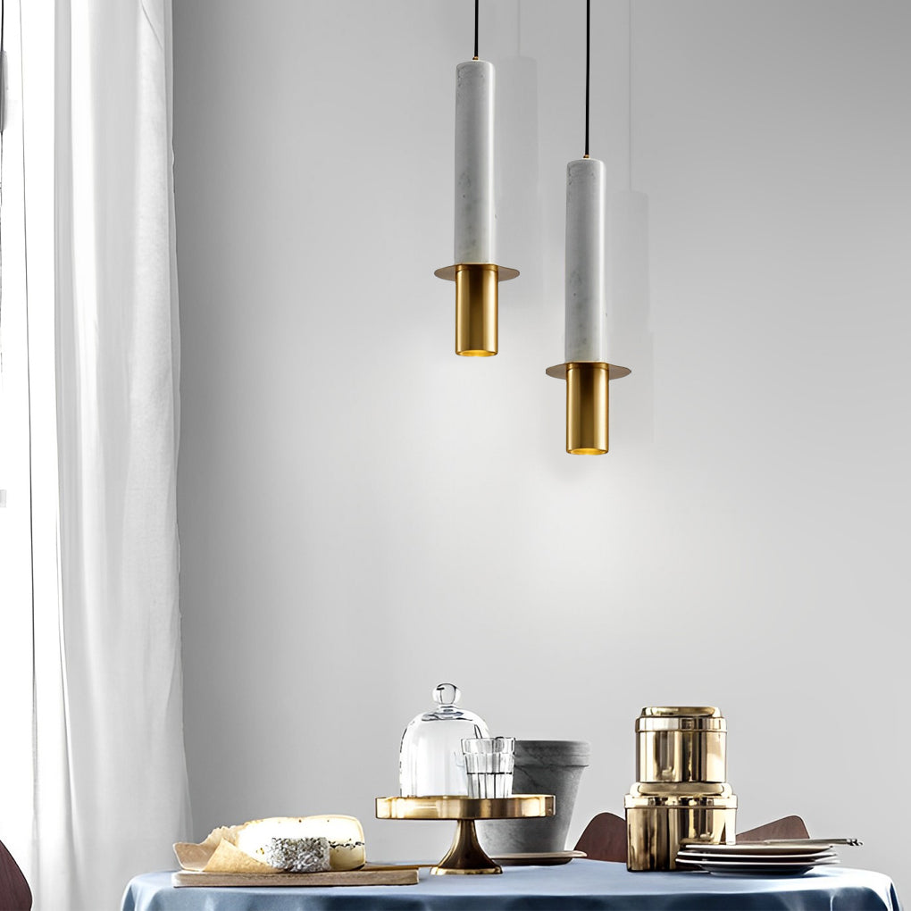 Staggered pair of white terrazzo cylinder pendant lights hanging in a modern white dining area.