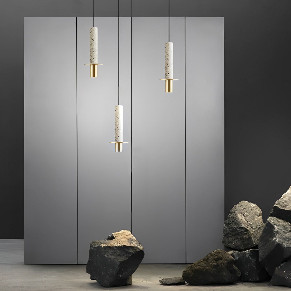 Trio of white terrazzo cylinder pendant lights staggered in a minimalist grey art studio room.